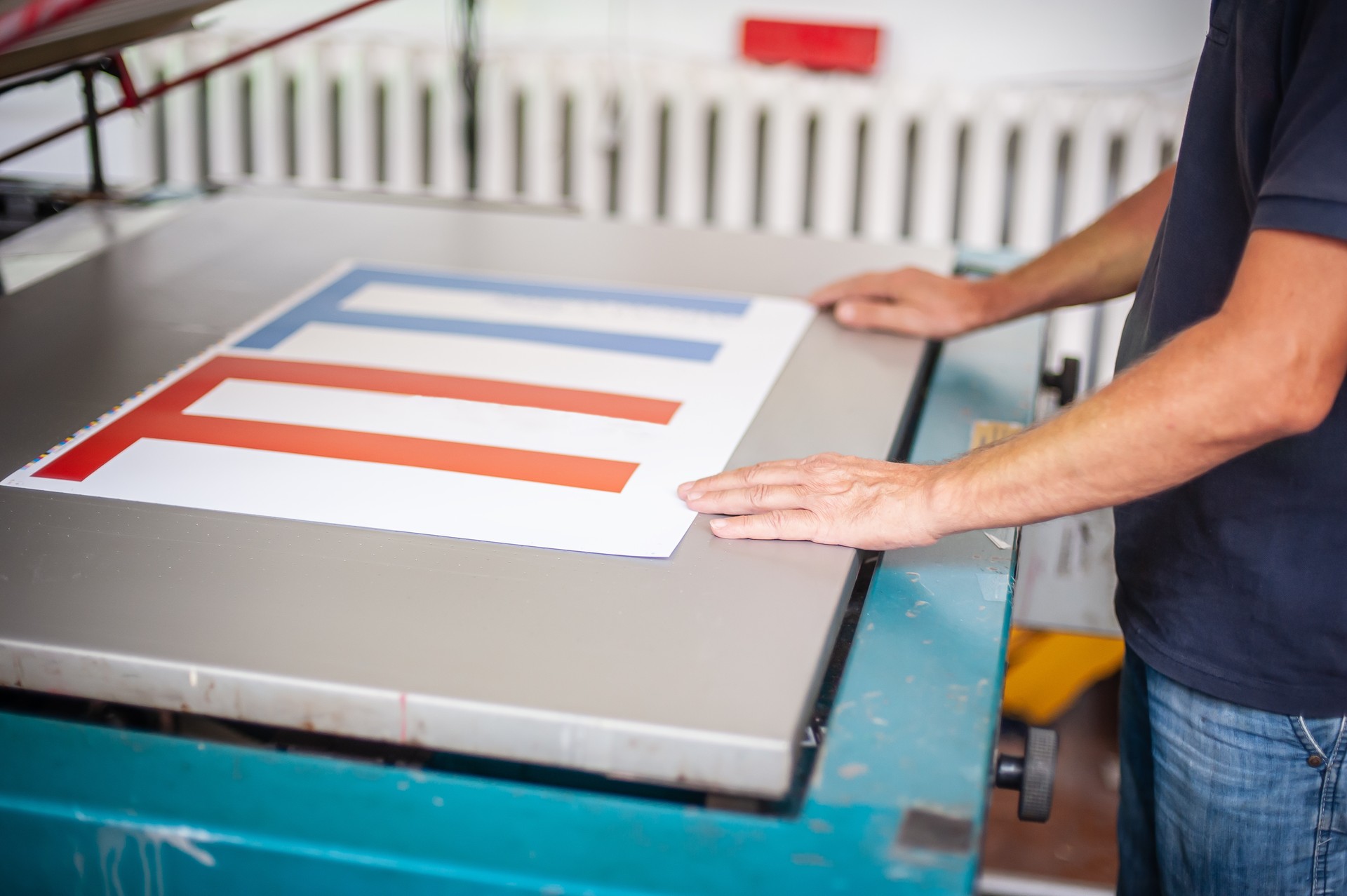 An experienced operator works on a screen printing machine